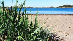 A beach with clear blue water and distant rocky hills. - 4 Star Holiday Home in Rabbalshede (Rabbalshede)