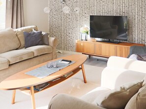A living room with a sofa, a coffee table, a television, and a cabinet. - 6 Person Holiday Home in Skummeslovsstrand (Skummesloevsstrand)