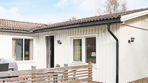 A white mobile home with a tiled roof, a wooden fence, and a small garden area. - 6 Person Holiday Home in Skummeslovsstrand (Skummesloevsstrand)