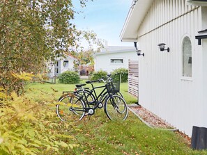 A residential area with a white building, a bicycle parked in front, and a grassy yard. - 6 Person Holiday Home in Skummeslovsstrand (Skummesloevsstrand)
