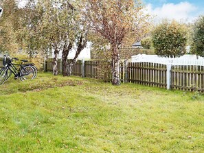 A grassy area with a bicycle parked by a wooden fence. - 6 Person Holiday Home in Skummeslovsstrand (Skummesloevsstrand)