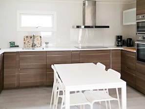 A modern kitchen with a white countertop, stainless steel range hood, and a built-in oven. - 6 Person Holiday Home in Skummeslovsstrand (Skummesloevsstrand)