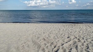 A beach with white sand and a calm sea under a clear sky. - 5 Star Holiday Home in Vaeggerlose (Vaeggerlose)