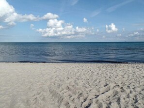 A beach with white sand and a calm sea under a clear sky. - 5 Star Holiday Home in Vaeggerlose (Vaeggerlose)
