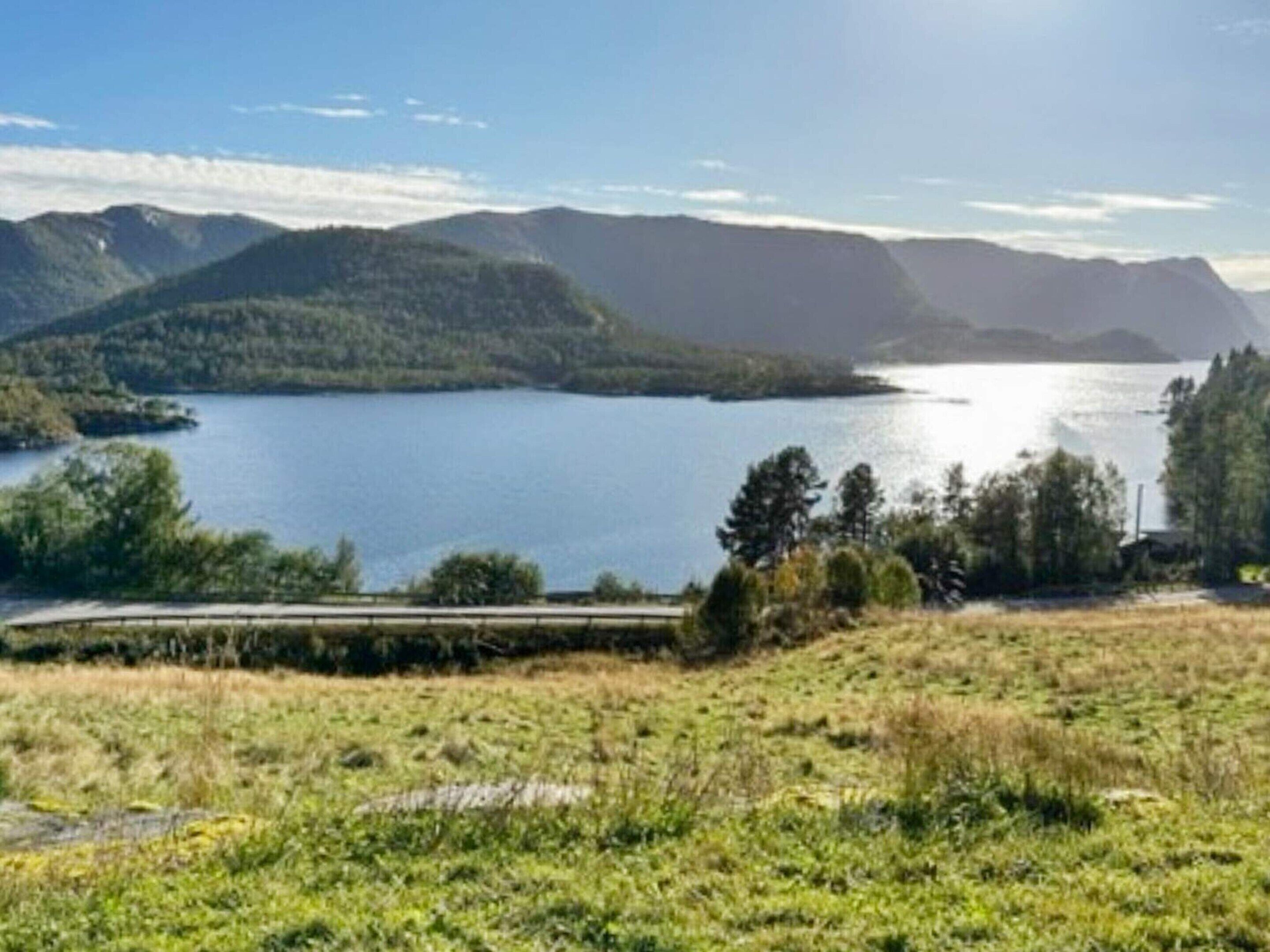 A scenic view of a lake surrounded by mountains and greenery.