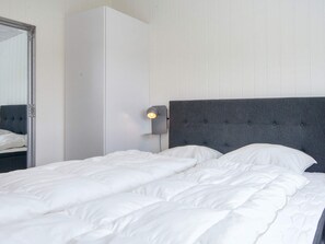 A bedroom with a large bed, a wardrobe, and a wall-mounted lamp. - 5 Star Holiday Home in Lemvig (Lemvig)