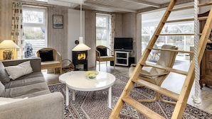 A cozy living room with a fireplace, a television, and a wooden ladder. - 6 Person Holiday Home in Karrebaeksminde (Karrebæksminde)