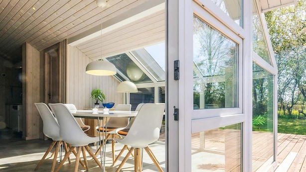 A modern dining area with a table, chairs, and pendant lights. - 6 Person Holiday Home in Karrebaeksminde (Karrebæksminde)