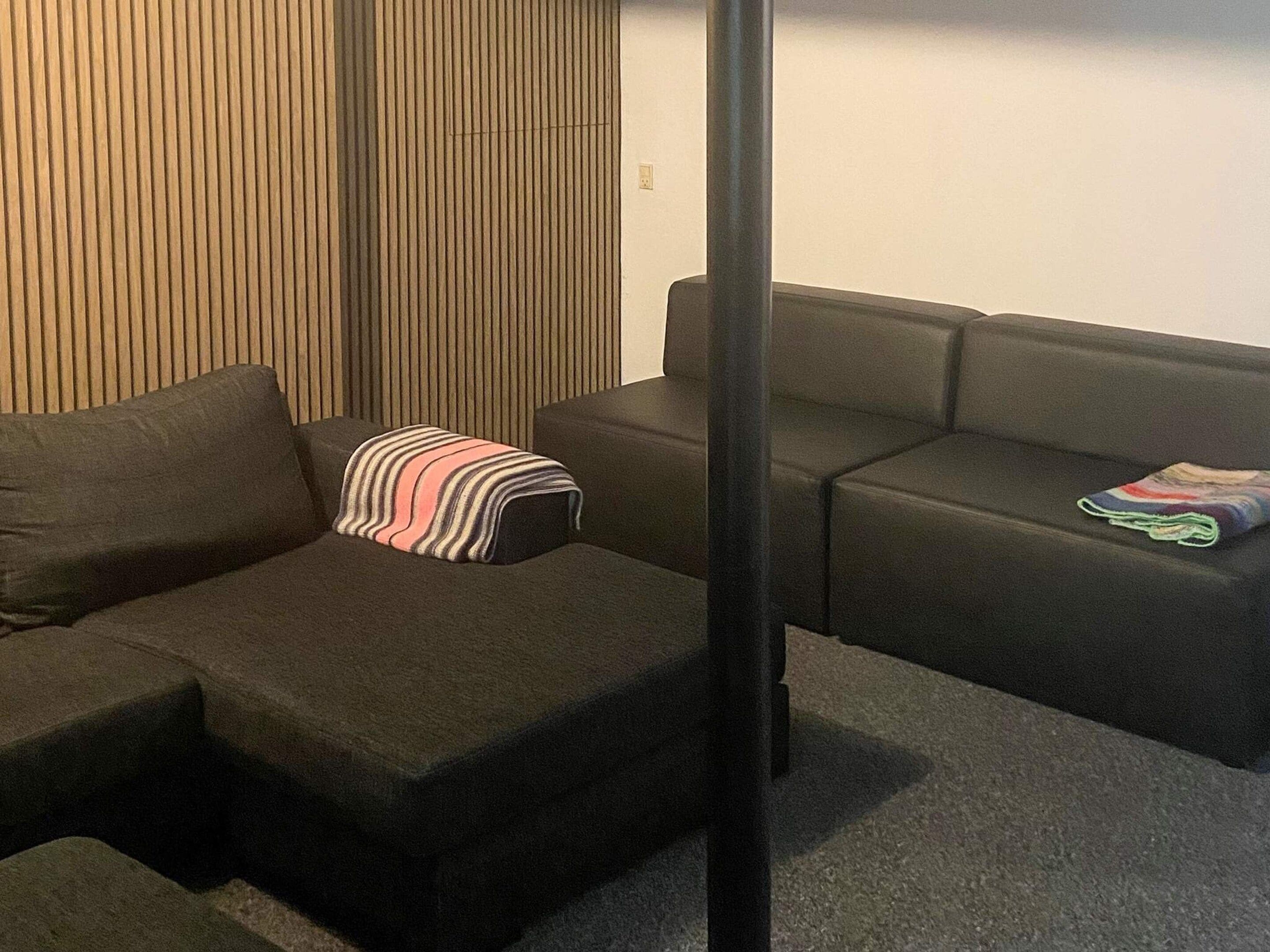 Ett modernt vardagsrum med en hörnsoffa, en randig prydnadskudde och ett litet bord.