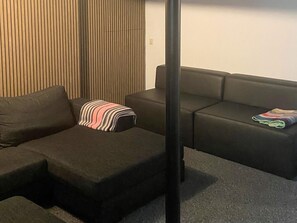A modern living room with a sectional sofa, a striped throw pillow, and a small table. - 20 Person Holiday Home in Karby (Øster Assels)