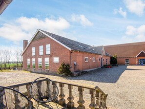 A brick building with a gravel driveway and a stone railing. - 20 Person Holiday Home in Karby (Øster Assels)