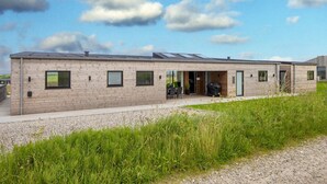 A modern building with a flat roof, large windows, and a covered outdoor area. - 5 Star Holiday Home in Lemvig (Lemvig)