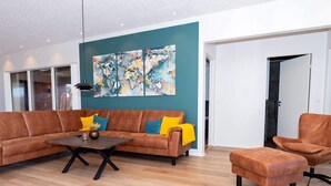A modern living room with a sectional sofa, a coffee table, and a single armchair. - 5 Star Holiday Home in Lemvig (Lemvig)