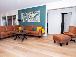 A modern living room with a sectional sofa, a coffee table, and a single armchair. - 5 Star Holiday Home in Lemvig (Lemvig)