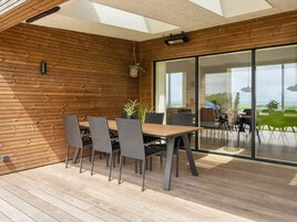 Un comedor moderno con una pared de madera, una mesa grande y sillas.