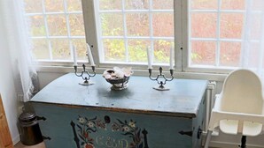 A room with a blue chest of drawers, a white chair, and a window with a view of trees. - 4 Star Holiday Home in Laholm-by Traum (Laholm)