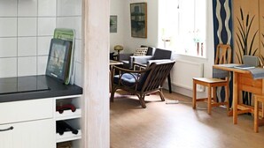A kitchen with white cabinets, a black countertop, and a wooden dining table with chairs. - 4 Star Holiday Home in Laholm-by Traum (Laholm)