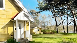A yellow house with a porch and steps leading to a door. - 4 Star Holiday Home in Laholm-by Traum (Laholm)