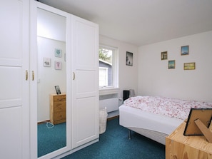 A bedroom with a bed, a wardrobe, a dresser, and a window. - 6 Person Holiday Home in Hojby (Hojby)