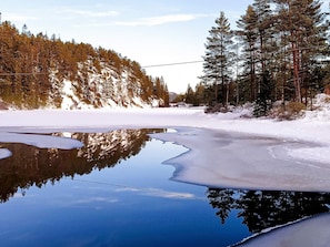 A frozen lake surrounded by dense forest. - 5 Person Holiday Home in Grimstad-by Traum (Grimstad)