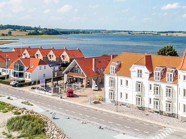 A coastal hotel with multiple buildings, a road in front, and a view of the sea. - 4 Star Holiday Home in Hejls (Hejls)