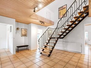 A staircase with a wooden finish and black metal railings, leading to an upper floor. - 4 Star Holiday Home in Ulfborg (Ulfborg)