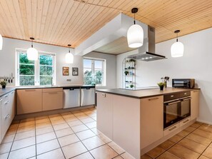 A modern kitchen with a central island, built-in appliances, and pendant lighting. - 4 Star Holiday Home in Ulfborg (Ulfborg)