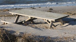 A wooden beach picnic table on a sandy shore with the ocean in the background. - 4 Star Holiday Home in Nordborg (Nordborg)