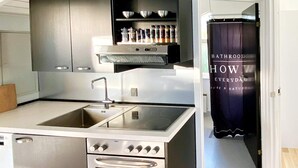 A modern kitchen with a stainless steel sink, double oven, and a built-in range hood. - 4 Star Holiday Home in Nordborg (Nordborg)