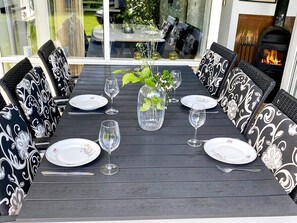 A dining table set for six with black and white patterned chairs, a vase with greenery, and wine glasses. - 4 Star Holiday Home in Nordborg (Nordborg)