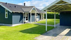 A two-story house with a covered patio area and a well-maintained lawn. - 4 Star Holiday Home in Nordborg (Nordborg)