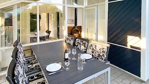 An outdoor dining area with a table set for four, surrounded by patterned chairs. - 4 Star Holiday Home in Nordborg (Nordborg)