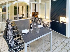 An outdoor dining area with a table set for four, surrounded by patterned chairs. - 4 Star Holiday Home in Nordborg (Nordborg)
