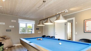 A pool table with three hanging lamps, a window with blinds, and a door with a sign. - 4 Star Holiday Home in Vaeggerlose (Vaeggerlose)