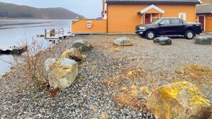Un bâtiment avec une allée gravillonnée et un véhicule garé.
