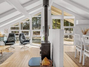 A spacious loft with high ceilings, large windows, and a central wood-burning stove. - 6 Person Holiday Home in Albaek (Aalbaek)