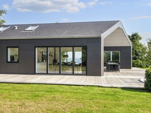 Et moderne hus med fladt tag, store glasfacader og en terrasse.