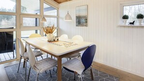A dining area with a wooden ceiling, white paneled walls, a large window, and a table with chairs. - 6 Person Holiday Home in Jerup (Jerup)