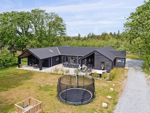 A modern house with a large patio area, a trampoline, and a covered outdoor seating area. - 5 Star Holiday Home in Henne (Henne)