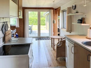 A kitchen with a sink, stove, and dining area with a table and chairs. - 6 Person Holiday Home in Struer (Struer)