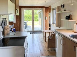 Una cucina con lavello, fornelli e zona pranzo con tavolo e sedie.