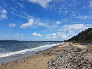 Una spiaggia con ciottoli e cielo sereno.