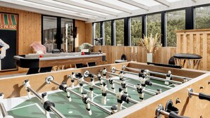 A room with a foosball table, a billiards table, and a window with a view of trees. - 8 Person Holiday Home in Oksbol (Oksbol)