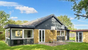 A modern house with a sloped roof, large windows, and a brick exterior. - 8 Person Holiday Home in Skjern (Skjern)