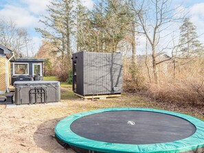 A backyard with a trampoline, a grill, and a storage shed. - 8 Person Holiday Home in Skjern (Skjern)