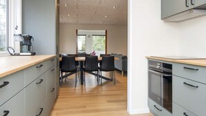 A modern kitchen with grey cabinets, a built-in oven, and a coffee machine. - 8 Person Holiday Home in Skjern (Skjern)