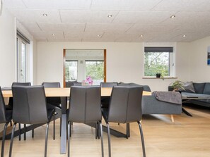 A modern conference room with a long table and chairs, large windows, and a view of greenery outside. - 8 Person Holiday Home in Skjern (Skjern)