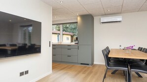 A modern kitchen with grey cabinets and a wooden dining table with black chairs. - 8 Person Holiday Home in Skjern (Skjern)