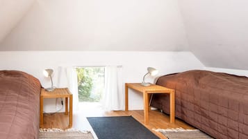 Un dormitorio con dos camas, una ventana con cortinas y vistas a zonas verdes.