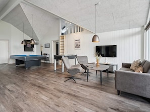 A modern living room with a pool table, two armchairs, a sofa, a TV, and a ceiling with exposed beams. - 5 Star Holiday Home in Sydals (Sydals)
